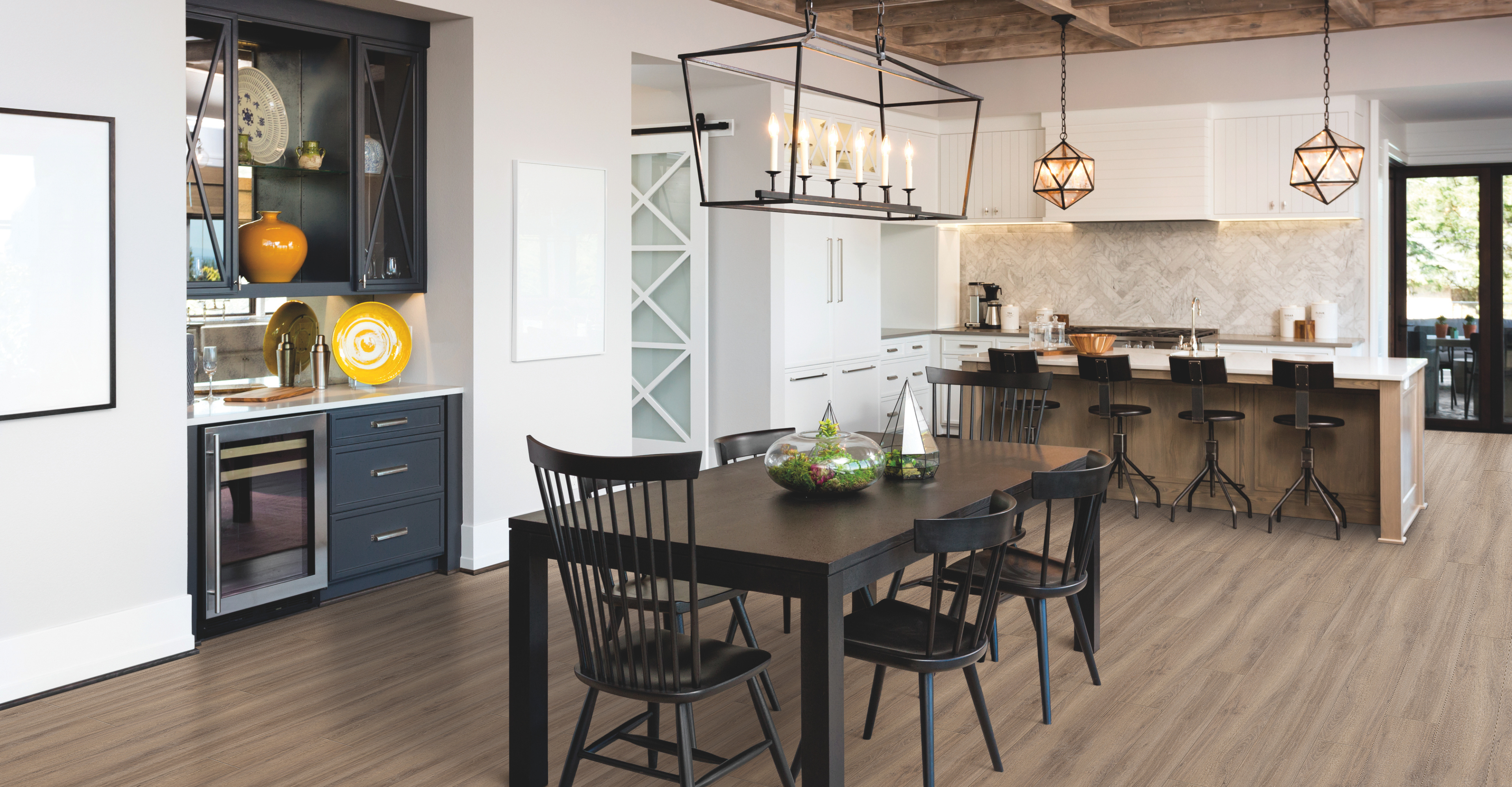 luxury vinyl plank flooring in a kitchen and dining area with white cabinetry and a white tile backsplash